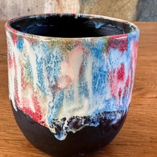 Zwarte beker met kleurenpallet rood, blauw, groen en wit